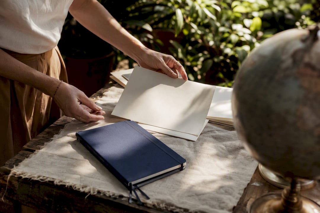 Hands arranging travel branding materials on desk