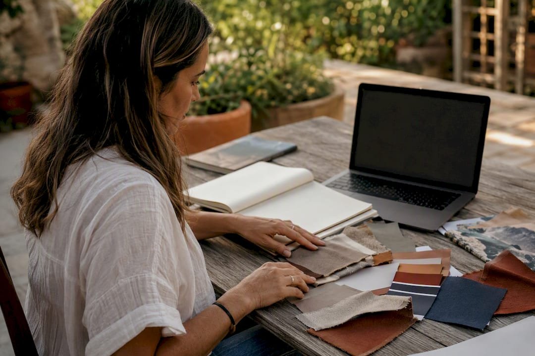 Hands arranging branding materials on rustic desk