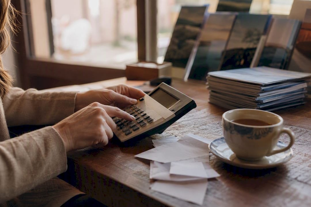 Hands calculating travel commissions with calculator