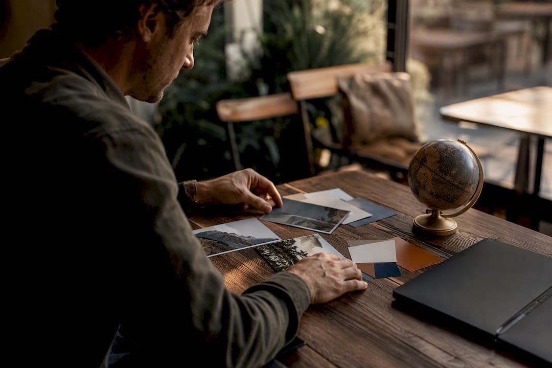 Hands arranging travel brochures on desk